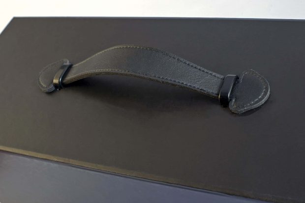 Leather-like handle with finishing seams and metal ferret